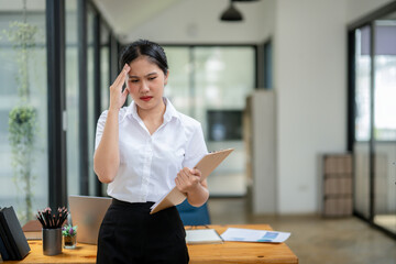 Stressed young apprentice businesswoman working on project paperwork error.