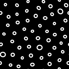 Seamless neutral rings pattern. White hand-drawn oval isolated on black background. Doodle dots cozy ornament. Vector illustrations with circles for wallpaper, posters, wrapping paper, textile, fabric