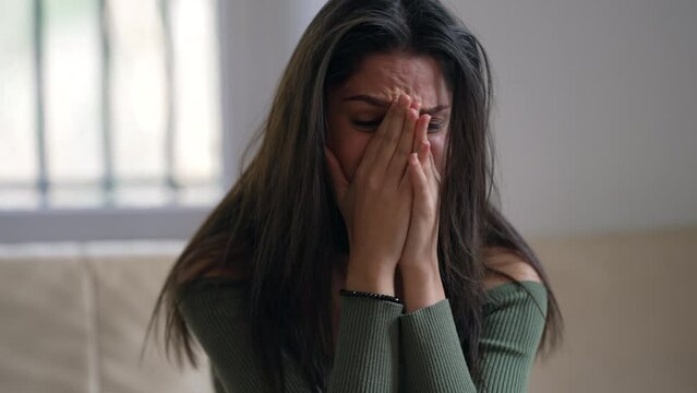Frustrated Adult Girl suffering from Emotional pain. Desperate young woman closeup face at home crying feeling hopeless