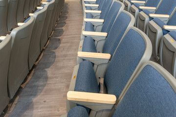 Close up image of empty gray and blue theater, auditorium seats, chairs.	