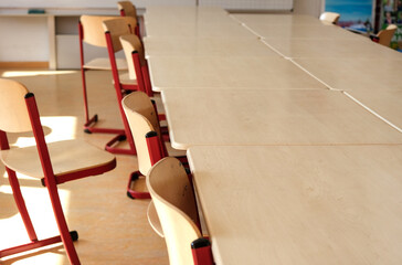 Detailansicht auf einige leere Stühle und Tische in einem Klassenzimmer in einer Schule Seminar- oder Konferenzraum, selektiver Fokus, viel Copy space - obrazy, fototapety, plakaty