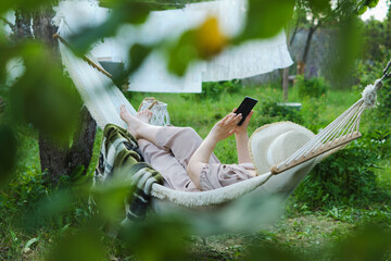 Golden Hour Bliss: Woman in Hat Finds Perfect Balance Between Nature and Technology, Basking in...