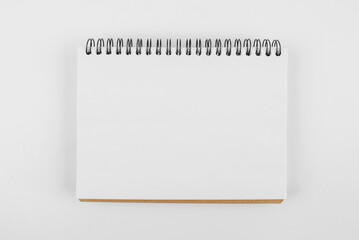 Close-up photo of a blank white notepad on a white background.