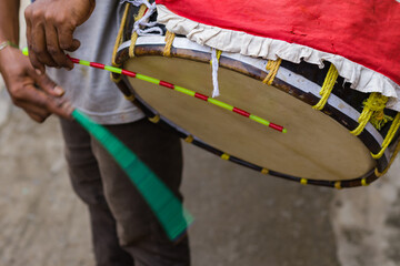 dhak or bengali drum being played during durga puja festival. It is a membranophone musical instrument played by hand with cane sticks. dhaki is the person who plays it.