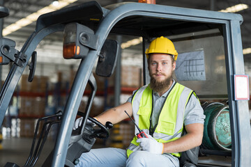 Male warehouse worker driving and operating on forklift truck for transfer products or parcel goods...