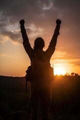 Fototapeta premium shot of a young female ranger standing in front of the sunset with her arms raised