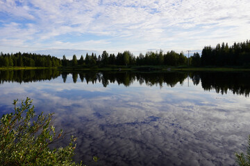 Fototapeta premium Wunderschöne Wolkenspiegelung im See bei Vojman in Schweden im Sommer