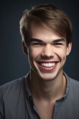Fototapeta premium portrait of a handsome young man smiling against a gray background
