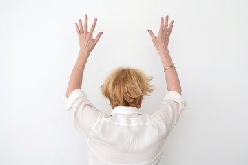 studio shot of an unrecognisable woman standing with her hands raised against a white background