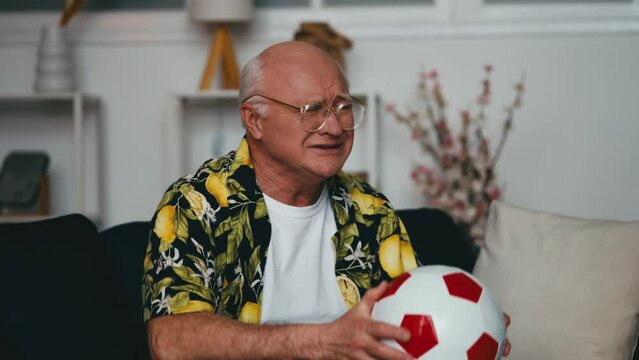 Excited senior man watching football game, displeased with teams loss, upset fan