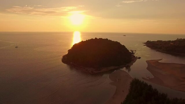.aerial view the sun above Kala island at Layan beach Phuket..colorful yellow sky of sunset at horizon.Phuket beach sea Amazing beach, .Beautiful beach Phuket Thailand, Nature and travel concept..