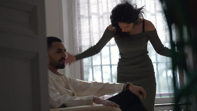 Relationship Woes: Candid Man Sits on Couch as Girlfriend nags and yells about Problems in Relationship. Desperate woman yelling and screaming to unresponsive man