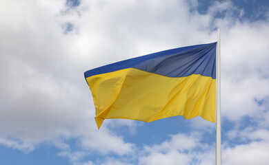 flag of Ukraine with colors blue above yellow below waving in the sky
