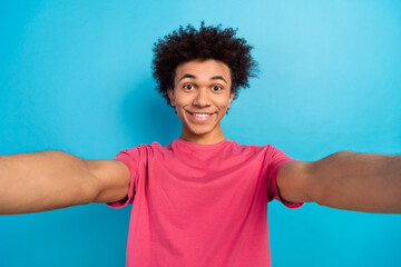 Portrait of cheerful guy with afro hairdo dressed stylish t-shirt making selfie on frontal camera...