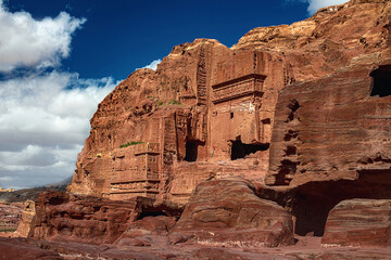 View of temples carved into sandstone rocks at daytime in Siq Gorge, Petra, Jordan.