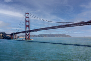 Fototapeta na wymiar San Francisco, CA, USA - July 13, 2023: Golden Gate bridge south landing with 1 tower under blue cloudscape and green ocean water.