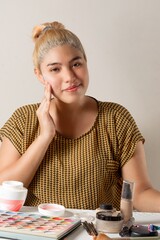 Young latin american woman making a makeup and making live video with a phone, influencer concept.