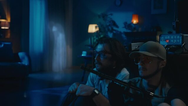 Two ghost hunters hiding behind the table. A glowing female silhouette , ghost, entity standing on the background, then appearing next to them. The men are scared and frightened.