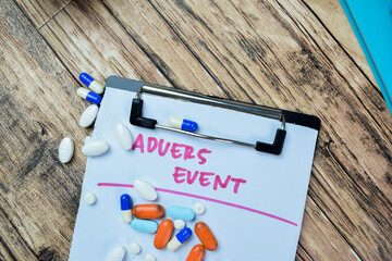 Concept of Adverse Event write on paperwork isolated on Wooden Table.