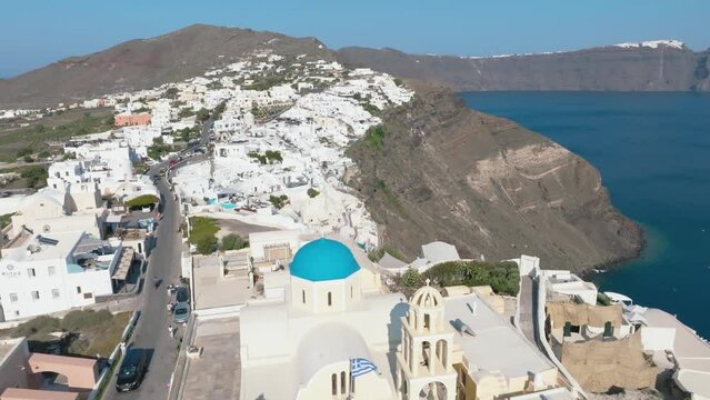 Sunny Santorini's coastal splendor from a drone.