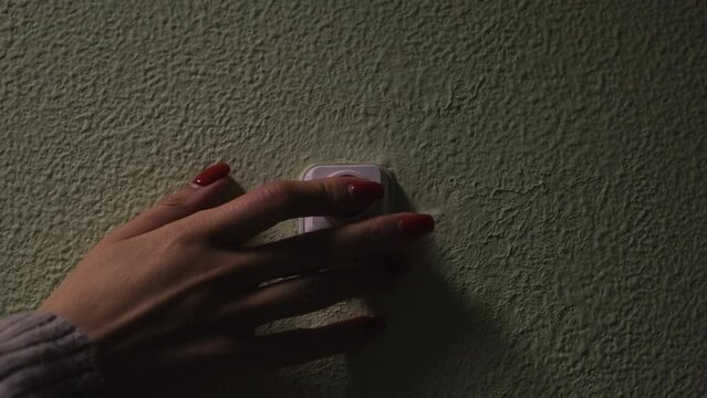 Hand pressing doorbell. Concept. Close-up of man's hand pressing bell. Lovers ring bell on wall by door. Guest presses doorbell