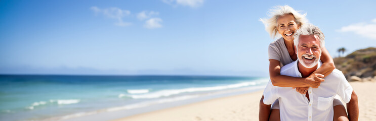 Happy senior couple on a tropical beach in the summer, woman is piggybacking on her husband. Concept of retirement and traveling when you are mature. Shallow field of view with copy space. 