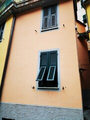 Photo of a vibrant yellow building with contrasting black window frames and shutters