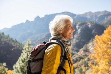 Naklejka premium An elderly woman hiking in the mountains.