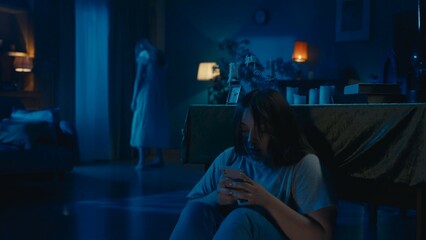 Shot of a young woman sitting, hiding behind the table from from an otherwordly creature, entity,...