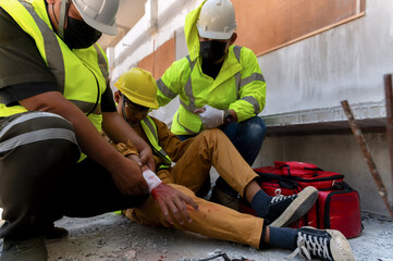 First aid team support to builder worker after hand injury bleeding, accident at work, Using...