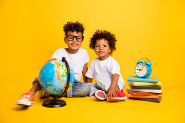 Full body photo of two little funny people sit floor planet earth globe pile stack book bell ring clock timer isolated on yellow color background