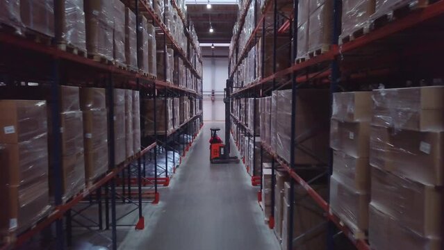 Warehouse with cardboard boxes inside on pallets racks, logistic center. Creative, Huge, large modern warehouse.