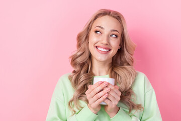 Portrait of model young woman blonde curly hair holding cup fresh coffee drink looking empty space dream isolated on pink color background
