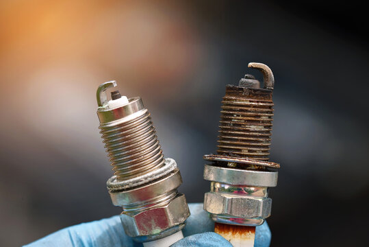 Spark plugs compare, new and old copper spark plugs. Spark plugs with worn electrodes and new one. Selective focus. Electrical ignition parts of gasoline engine.