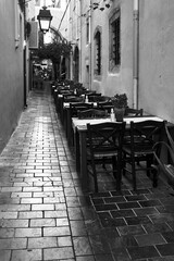 Restaurant chairs and tables set in a narrow street of the city of Chania on the island of Crete