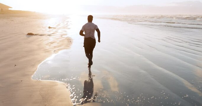 Man, beach and running in fitness, workout or exercise for outdoor training, motivation or cardio. Rear view of active male person, athlete or runner in sports, lose weight or healthy wellness by sea