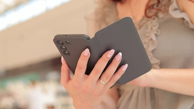 Gadget. Girl with a phone in her hands. Women's hands with a smartphone in a smart case, close-up. Use modern technologies, search on the internet, online purchases, online communication