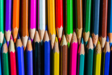 Background of bright multicolored pencils alternating with each other