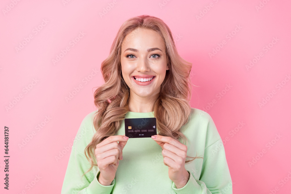 Sticker Portrait of girl blonde curls wear green pullover holding plastic black advertising credit agricole bank isolated on pink color background