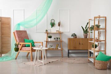 Interior of stylish room with armchair and dream catcher on wall