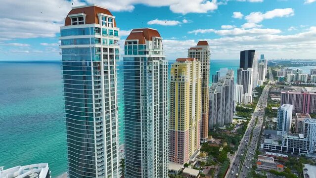 Sunny Isles Beach city with luxurious highrise hotels and condo buildings and busy ocean drive on Atlantic coast. American tourism infrastructure in southern Florida
