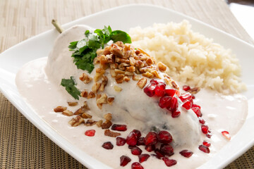 Chile en Nogada, Typical dish from Mexico. Prepared with poblano chili stuffed with meat and fruits and covered with a walnut sauce. Named as the quintessential Mexican dish for national holidays.