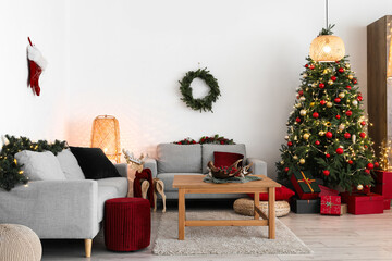 Interior of living room with Christmas tree, sofas and coffee table