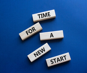 Time for a new start symbol. Wooden blocks with words Time for a new start. Beautiful deep blue background. Business and Time for a new start concept. Copy space.