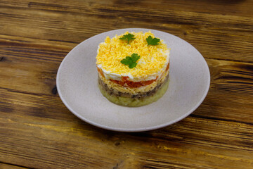 Traditional russian salad Mimosa on wooden table