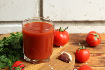 There is fresh tomato juice on a wooden table.	