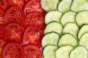 Cucumbers and tomatoes cut into circles lie on top of each other.