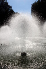 Splashes of water from the fountain against the backdrop of the bright sun.