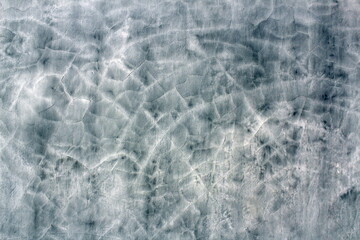 Gray concrete wall with cracked plaster.
