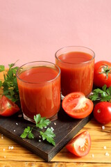 Two glasses of tomato juice are on the table.	